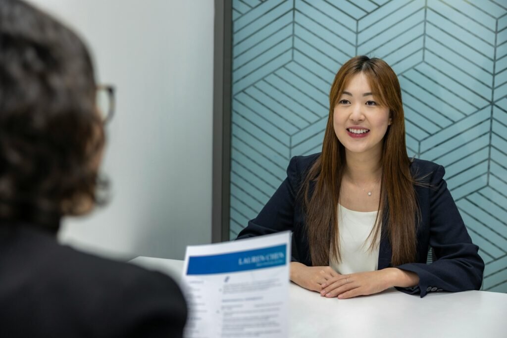 The Collapse of Modern Hiring: Why LinkedIn, Indeed & Modern Job Boards No Longer Work 2 Young woman in a business meeting with an interviewer, showcasing confidence and professionalism.