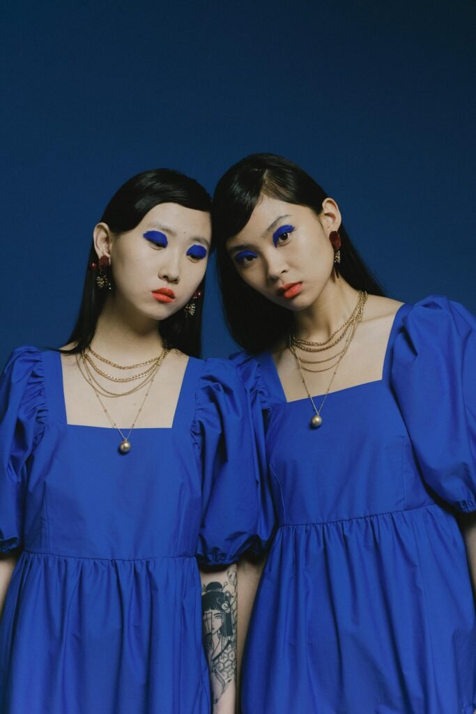 Evil Twin Wi-Fi Attacks: What Really Happens When You Connect to a Rogue Hotspot? 3 Two models in matching blue dresses with striking blue eyeshadow, posing against a blue backdrop.